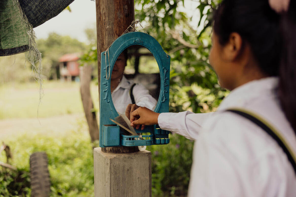 Photo de Rachana prenant un peigne devant son miroire